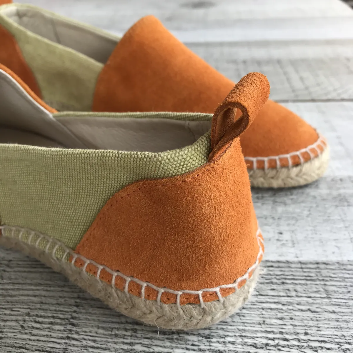 Détail du talon d’une espadrille en daim orange et toile verte, cousue sur semelle en jute.