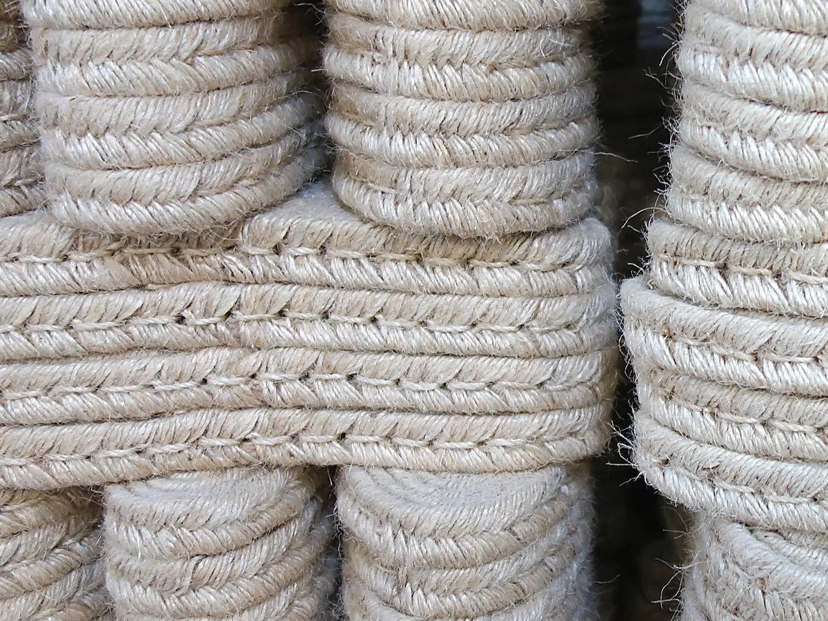 Braided jute soles, coiled and stitched, stacked in the workshop.